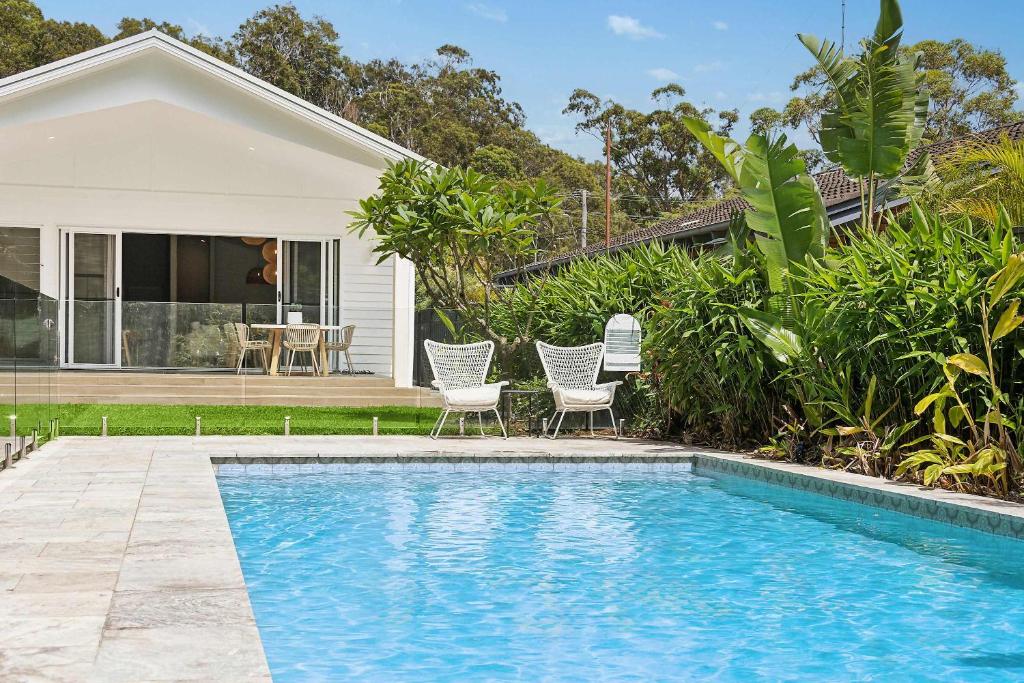 ein Swimmingpool vor einem Haus in der Unterkunft Cove Beach House by Coast Hosting in Umina Beach 