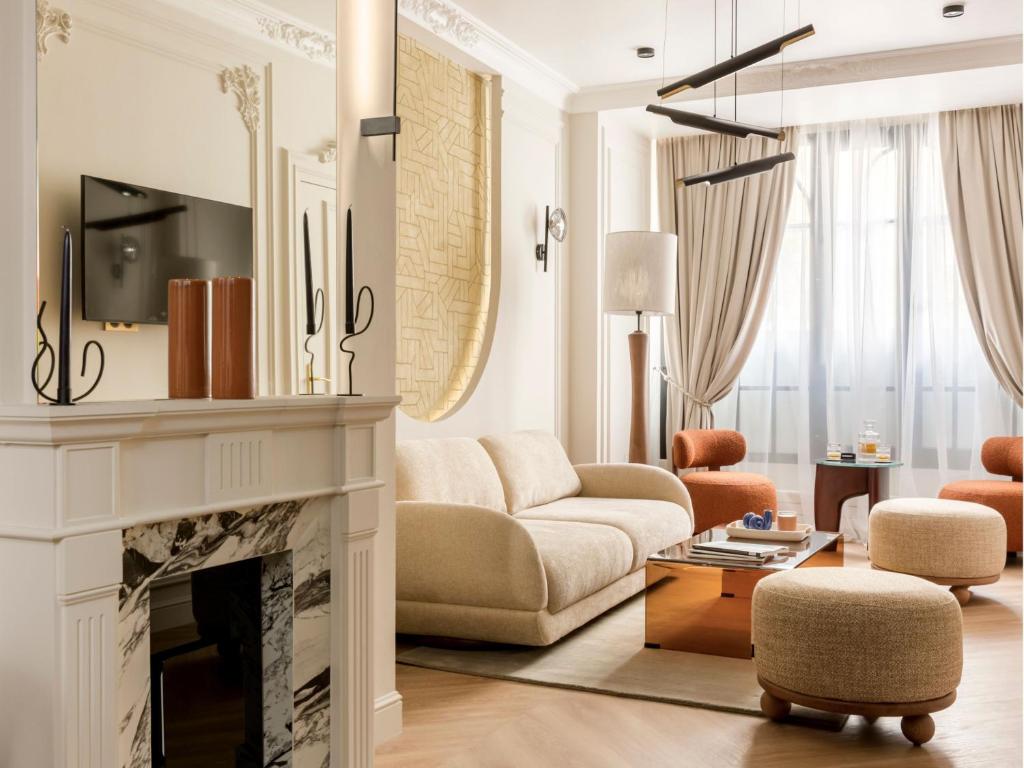 un salon avec un canapé et une cheminée dans l'établissement Merveil - Signature Suite -Tour Eiffel-Grenelle II, à Paris