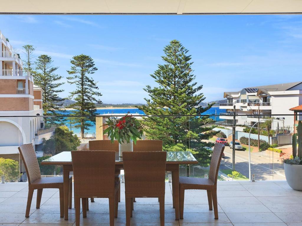 een eettafel en stoelen op een balkon met uitzicht bij PineTree Penthouse by Coast Hosting in Terrigal