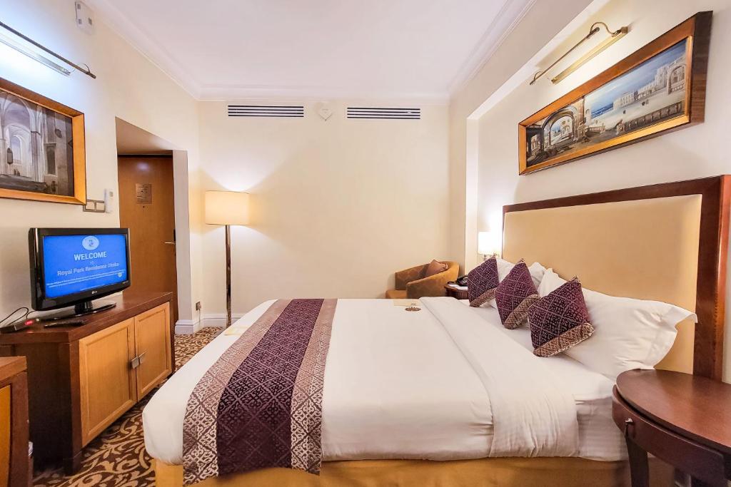 Una habitación de hotel con una cama y un televisor de pantalla plana. en Royal Park Residence Hotel, en Dhaka