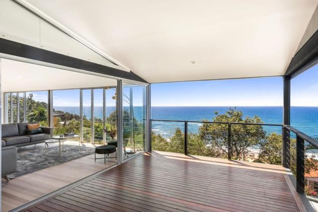 a house with a balcony with a view of the ocean at Sandcastle by Coast Hosting in Wamberal