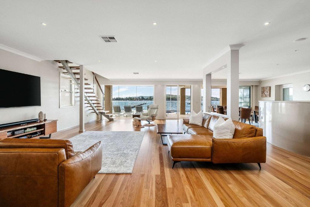 Una sala de estar con dos sofás y un televisor. en Serene By Coast Hosting, en Point Clare