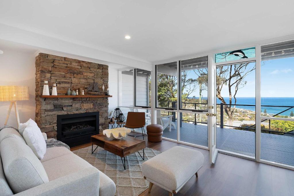a living room with a couch and a fireplace at The Glass House by Coast Hosting in Copacabana