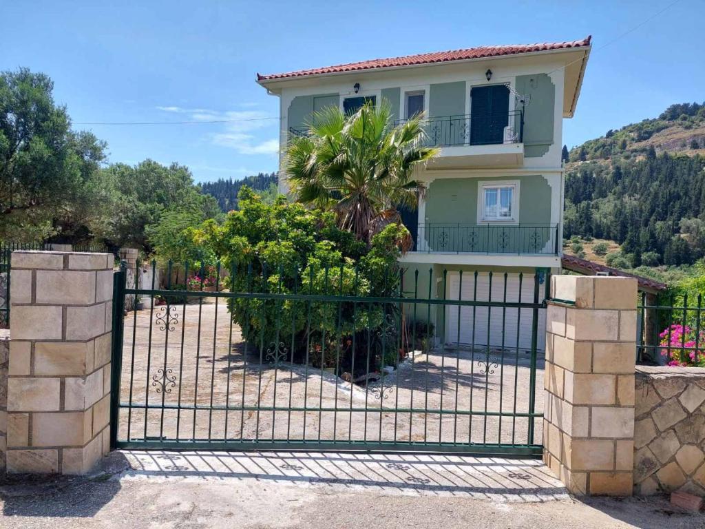 ein Haus mit einem Tor davor in der Unterkunft Evaggelatos Cottage in Lixouri