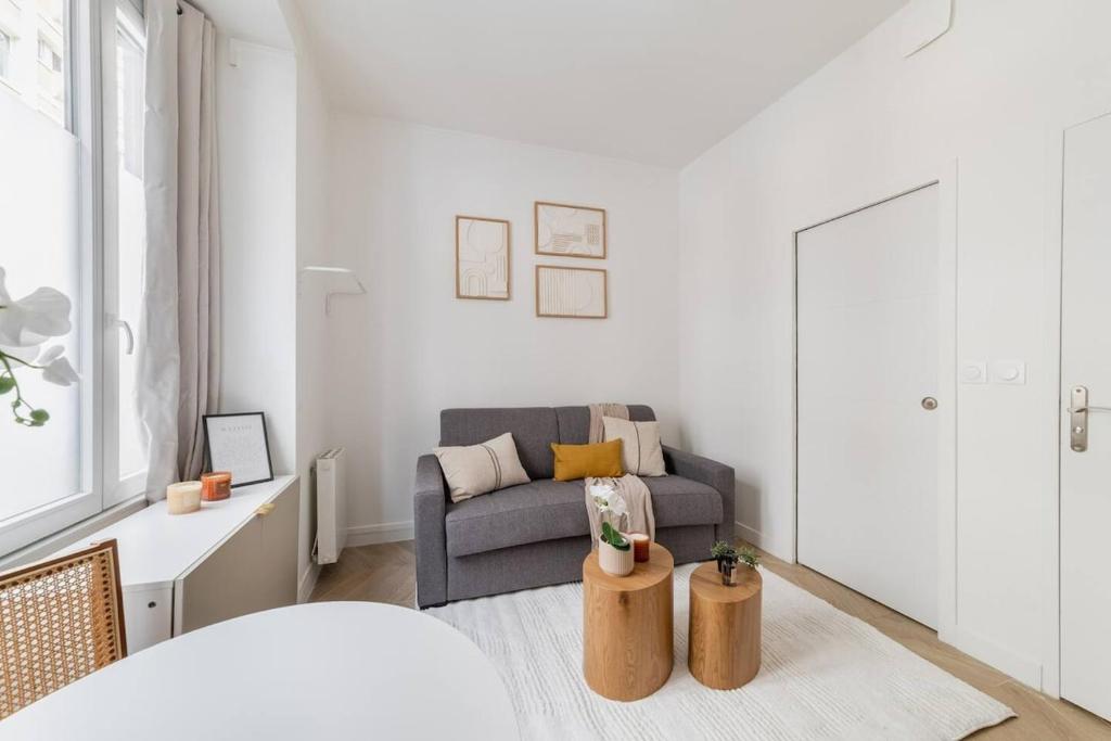 un salon avec un canapé et une chaise dans l'établissement Cozy studio in Montmartre, à Paris
