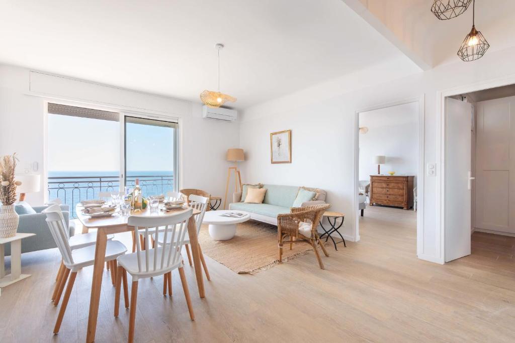 une salle à manger et un salon avec une table et des chaises dans l'établissement Cannes Sea View & Beach Access, à Cannes