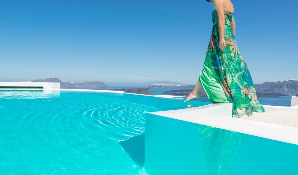 a woman standing on top of a swimming pool at Apanemo Hotel & Suites in Akrotiri