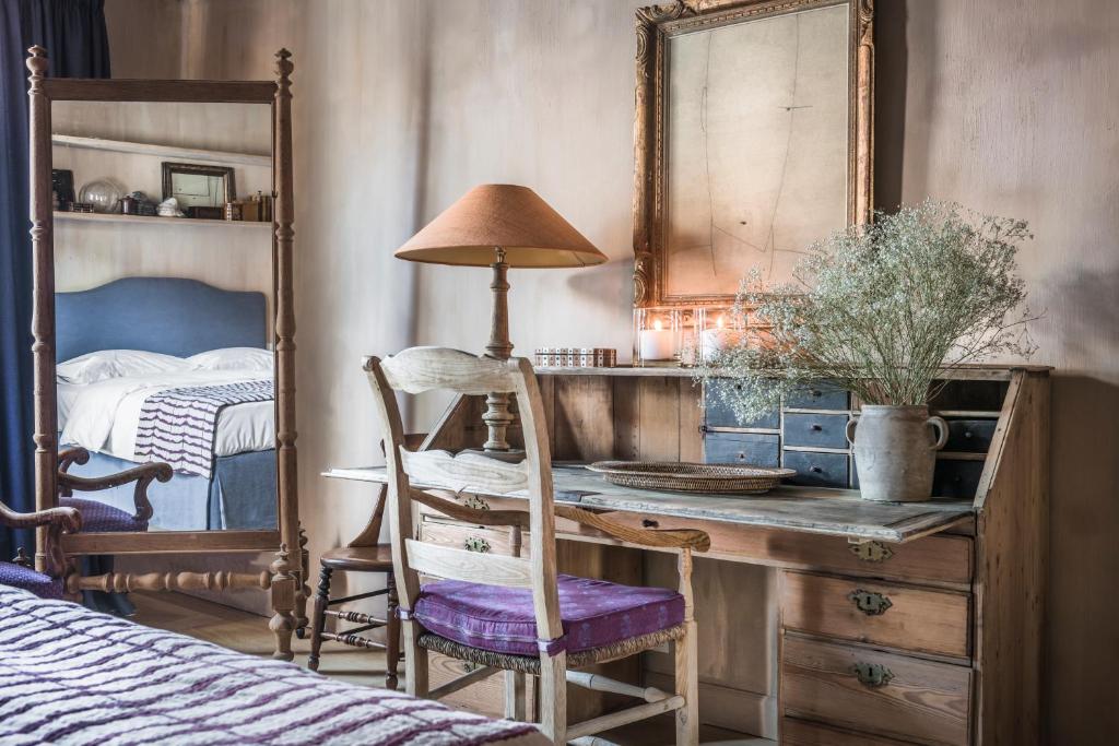 1 dormitorio con escritorio, espejo y cama en Odevaere - Charming & luxurious apartment with terrace, en Brujas