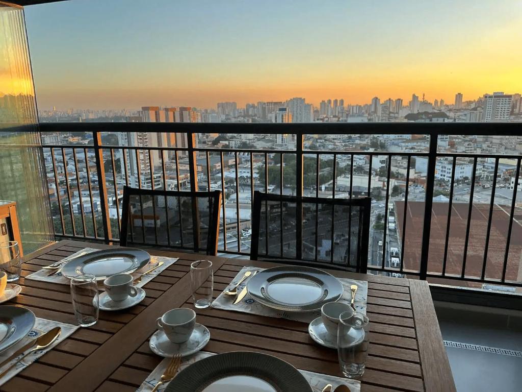 a table on a balcony with a view of the city at GRU Airport 4km, 2 Dorms, Bosque Maia in Guarulhos