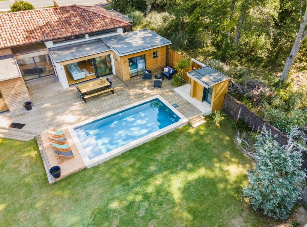 Cette chambre offre une vue sur une petite maison dotée d'une piscine. dans l'établissement Villa ELVIRA proche de l'océan, Angresse proche Hossegor, à Angresse