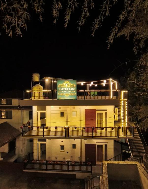 a building with a sign on top of it at night at Nature Oaks Luxury stayz Nainital in Bhīm Tāl