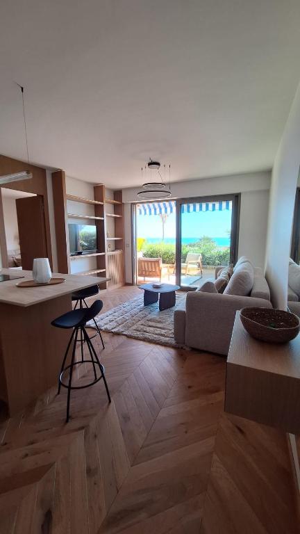 une cuisine et un salon avec un canapé et une table dans l'établissement Appartement design 1ère ligne avec vue panoramique sur la mer, à Cannes