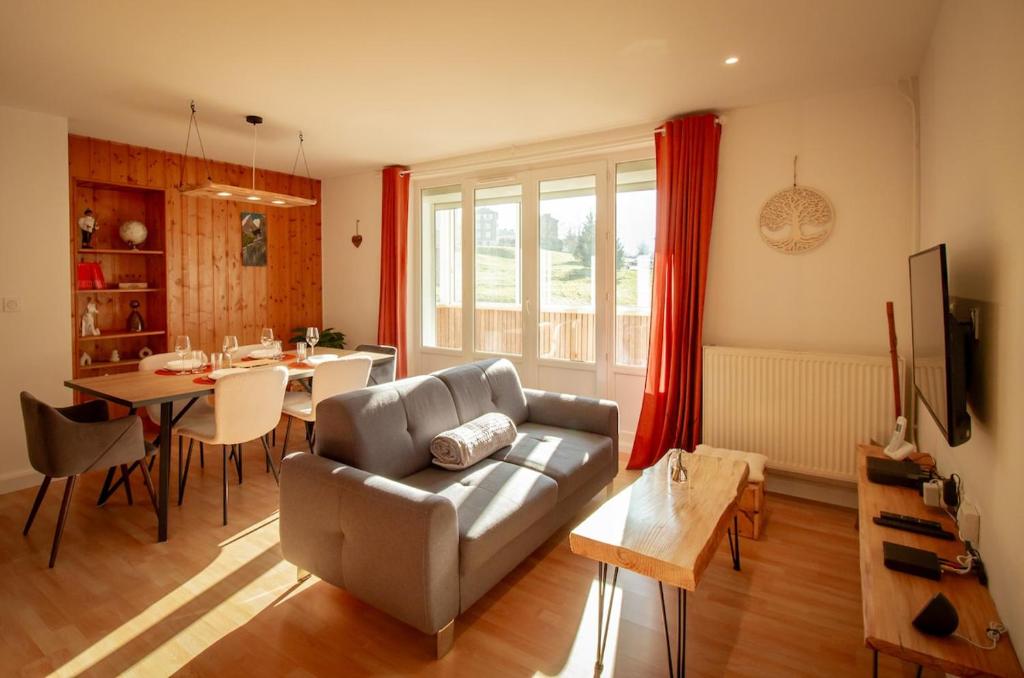 a living room with a couch and a table at L'Edelweiss - Au pied des montagnes in La Lechere