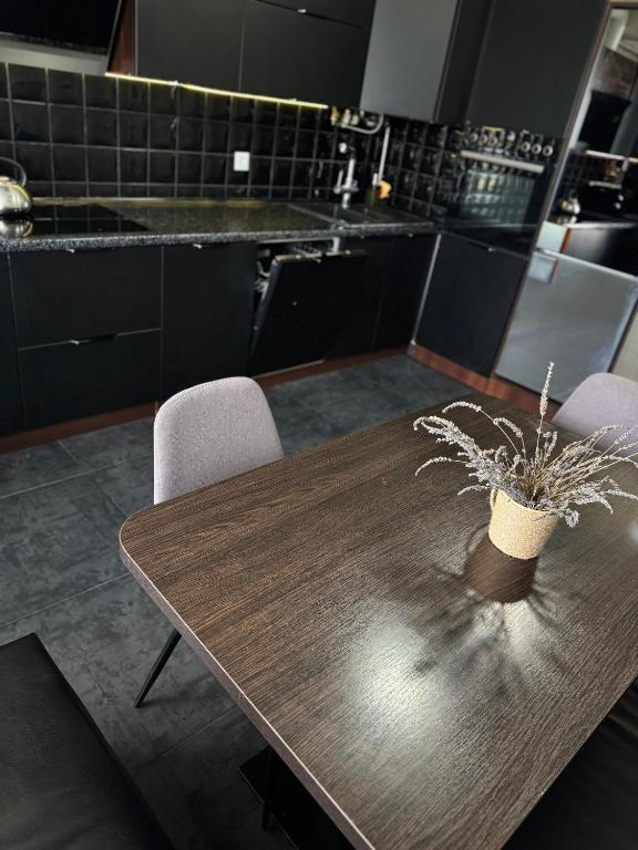 a kitchen with a wooden table and two chairs at Avangard in Chernivtsi