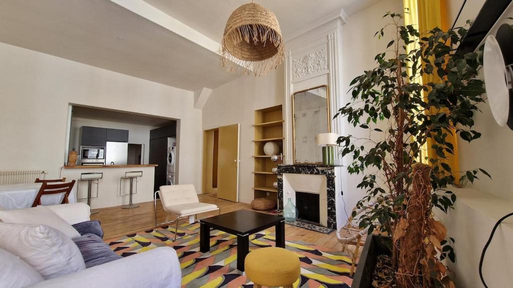 un salon avec un canapé blanc et une cheminée dans l'établissement St Michel 3 bedrooms appartment, à Bordeaux
