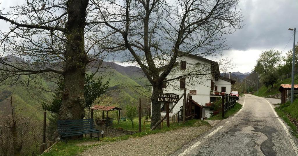 um sinal no lado de uma estrada ao lado de uma casa em Albergo Ristorante La Selva em Orsigna