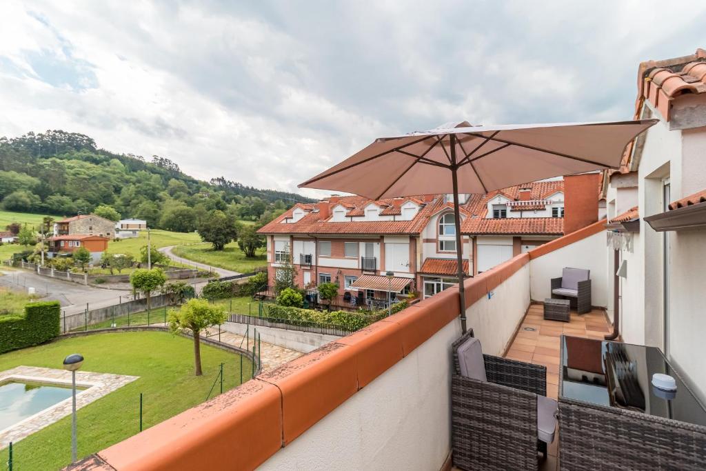 a balcony with an umbrella and a pool at Fabuloso apartamento con piscina in Vargas