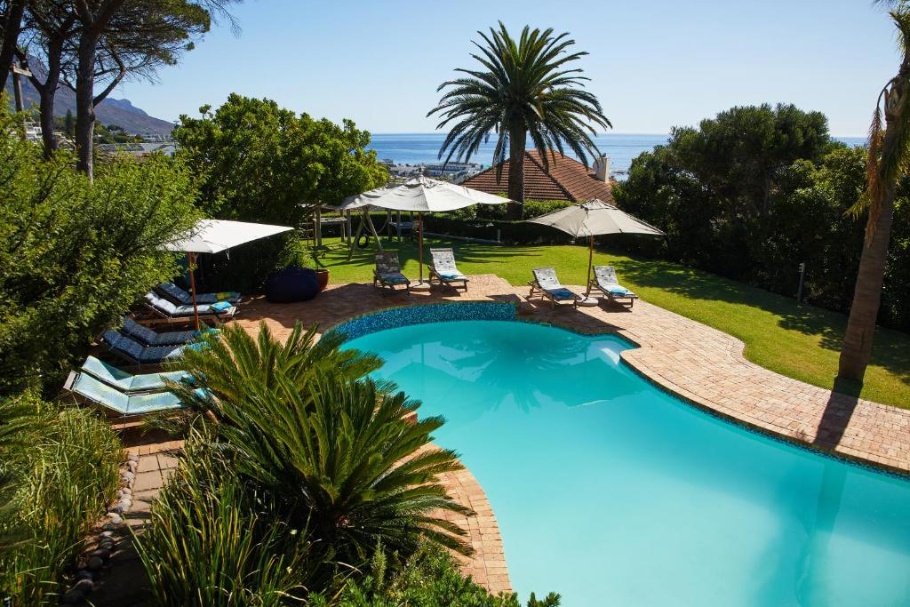 an overhead view of a swimming pool with chairs and umbrellas at 42 On Strathmore in Cape Town