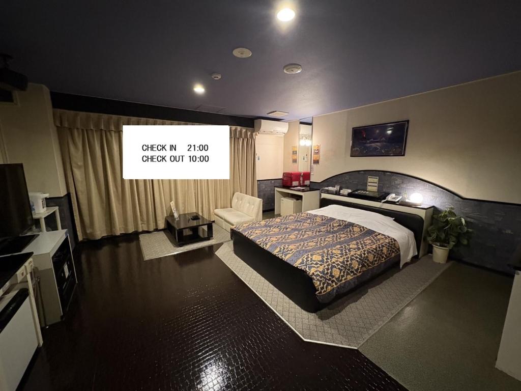 a bedroom with a bed and a tv in it at ホテル ウィズ男塾ホテルグループAdult Only in Fukuyama