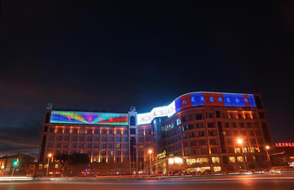 a building with colored lights on it at night at Kunming Plateau Pearl Hotel in Kunming