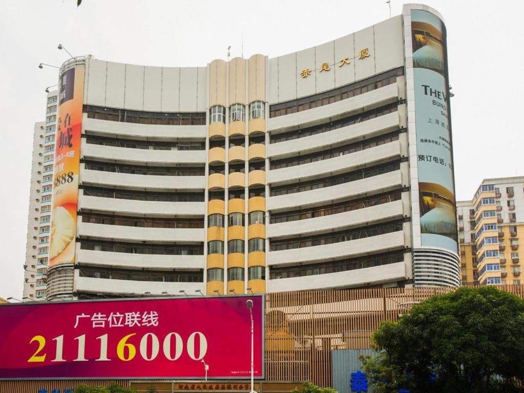 a large building with a sign in front of it at Jia Relax Hotel Shenzhen in Shenzhen