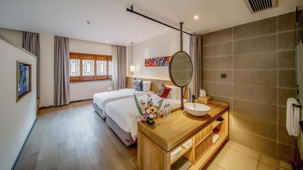 a bedroom with a bed and a sink and a mirror at Grand House Chongqing Dazu Rock Carvings in Dazu