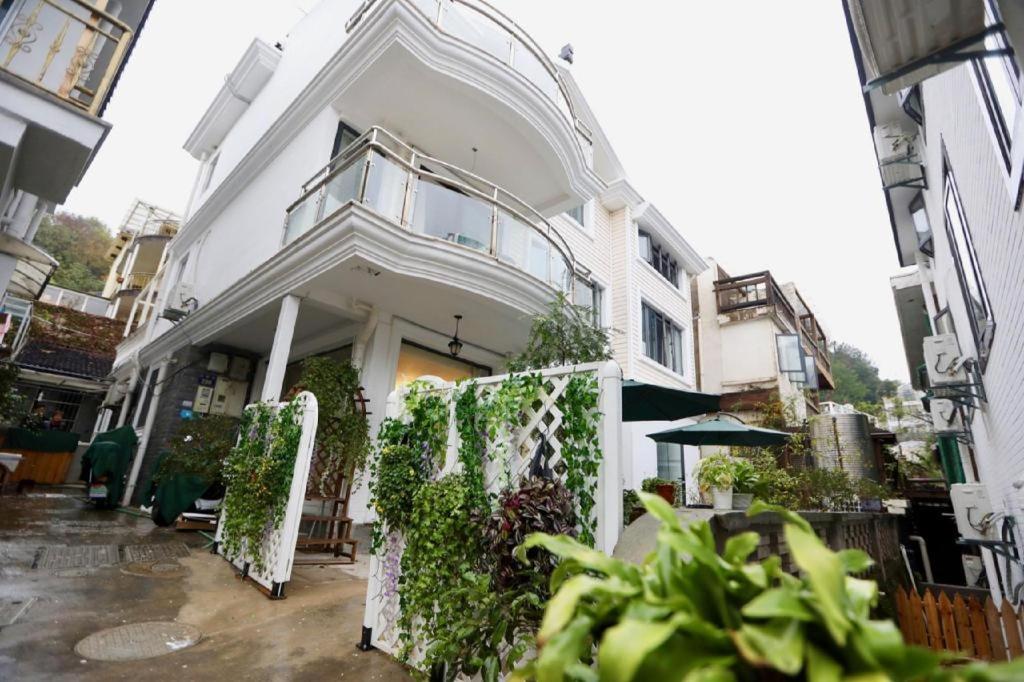 a white building with plants on the side of it at Banlan House in Hangzhou