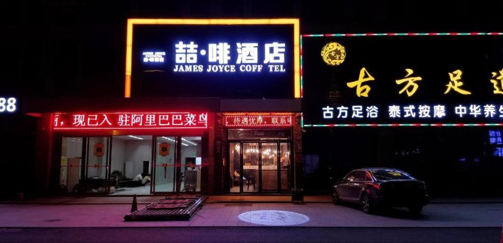 une voiture garée devant un immeuble avec des panneaux dans l'établissement James Joyce Coffetel·Hefei Heyu Road Zheshang City, à Hefei