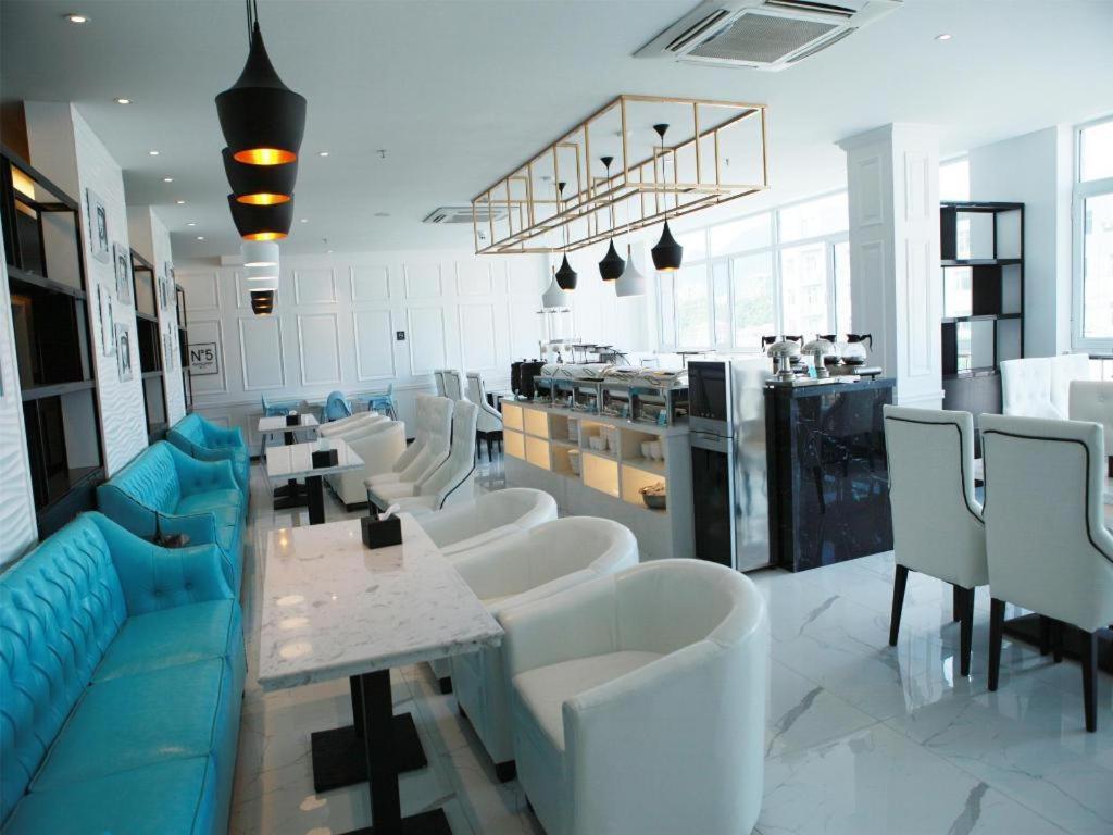 ein Restaurant mit weißen Tischen und weißen Stühlen in der Unterkunft Xana Lite·Chengde Xinglong County in Xinglong