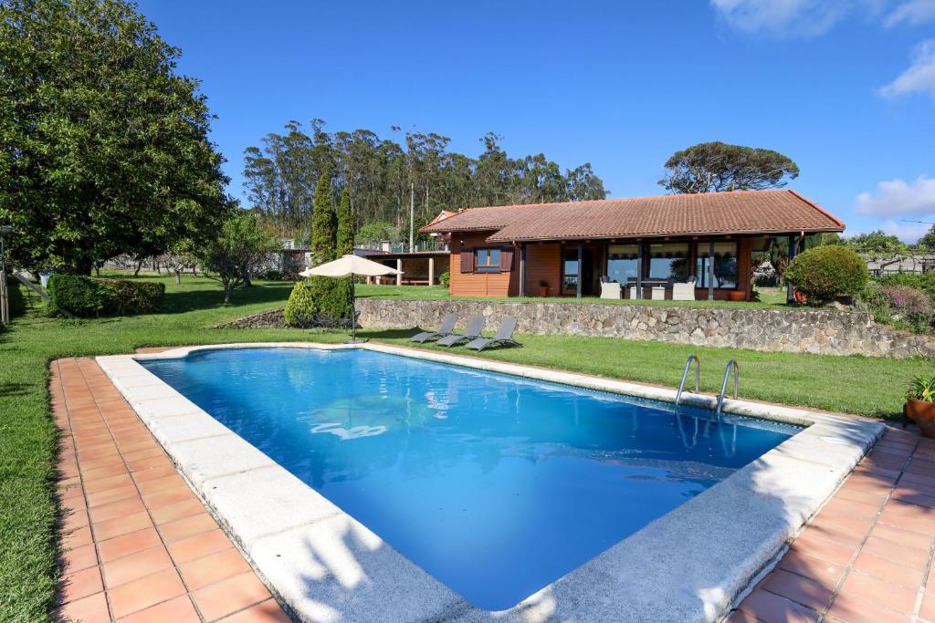 a swimming pool in front of a house at YourHouse Lar de Lagos in Bueu