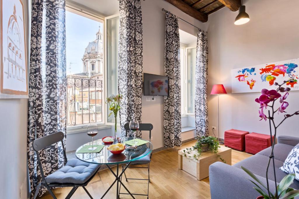 uma sala de estar com mesa e cadeiras em Rome as you feel - Grotta Pinta apartments em Roma