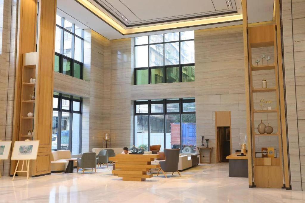 a large room with tables and chairs and windows at Longuu Hotel Zhaoqing in Zhaoqing