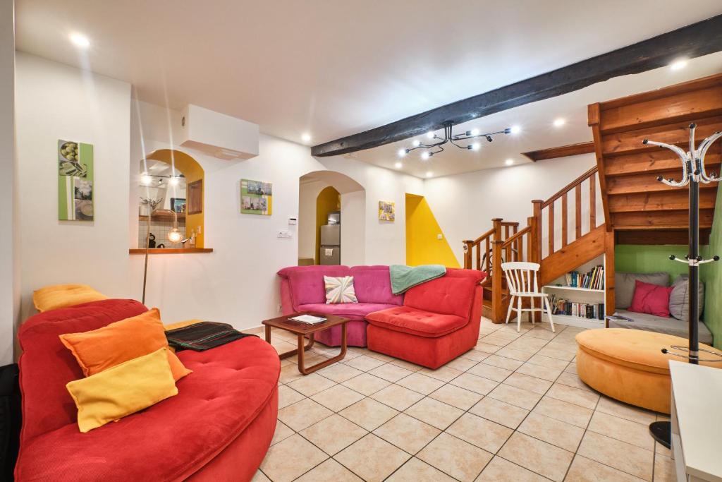 a living room with two couches and a staircase at Au 81 - Maison De Ville à Louer in Moirans