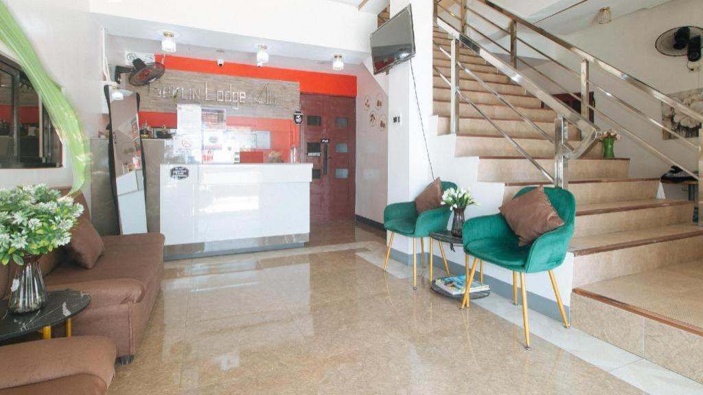 un salon avec un escalier et des chaises vertes dans l'établissement RedDoorz @ Gerlins Lodge Two, à Manille