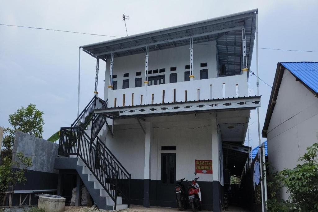 a white building with a staircase in front of it at Hotel O Penginapan Al-asharNearWarung Acil Ubai in Purbolinggo
