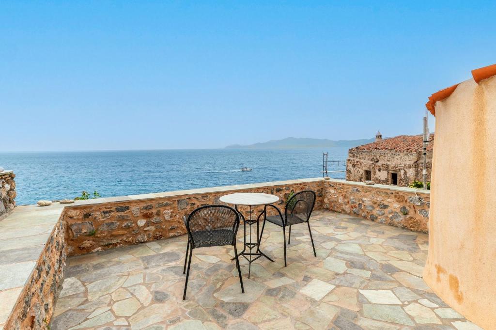 a table and two chairs on a balcony overlooking the ocean at Casa tradizionale Goulas in Monemvasia