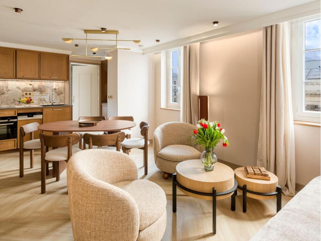 un salon avec des chaises et une table dans l'établissement Merveil - Signature Suite - Louvre - Bourse II, à Paris