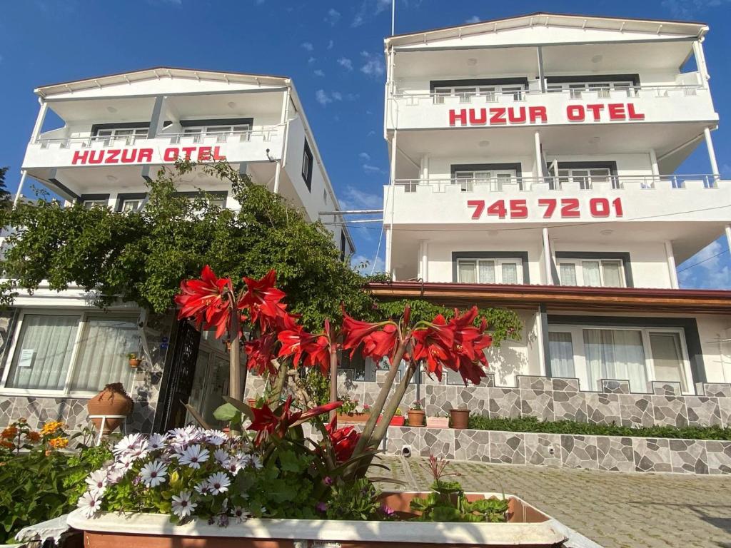 a building with flowers in front of it at Huzur Hotel in Siğacık