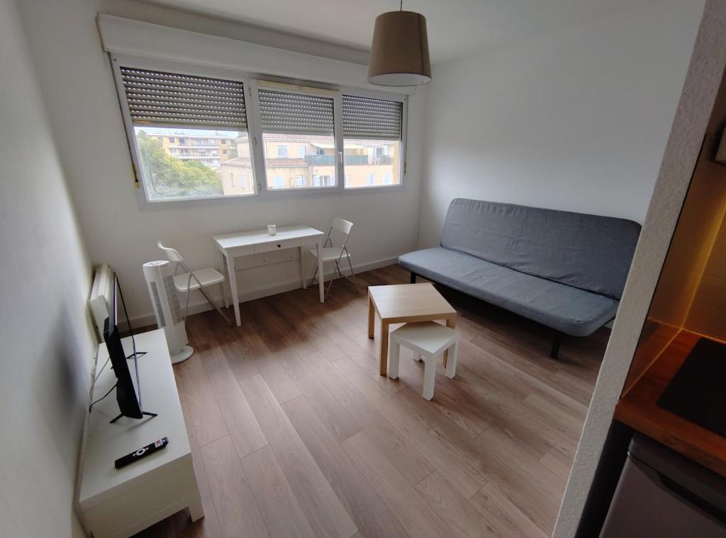 un petit salon avec un canapé et une table dans l'établissement Studio proche remparts, à Avignon
