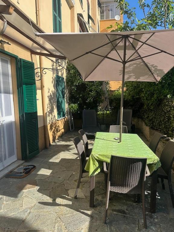 stół i krzesła z parasolem na patio w obiekcie Varazze Apartment w mieście Varazze