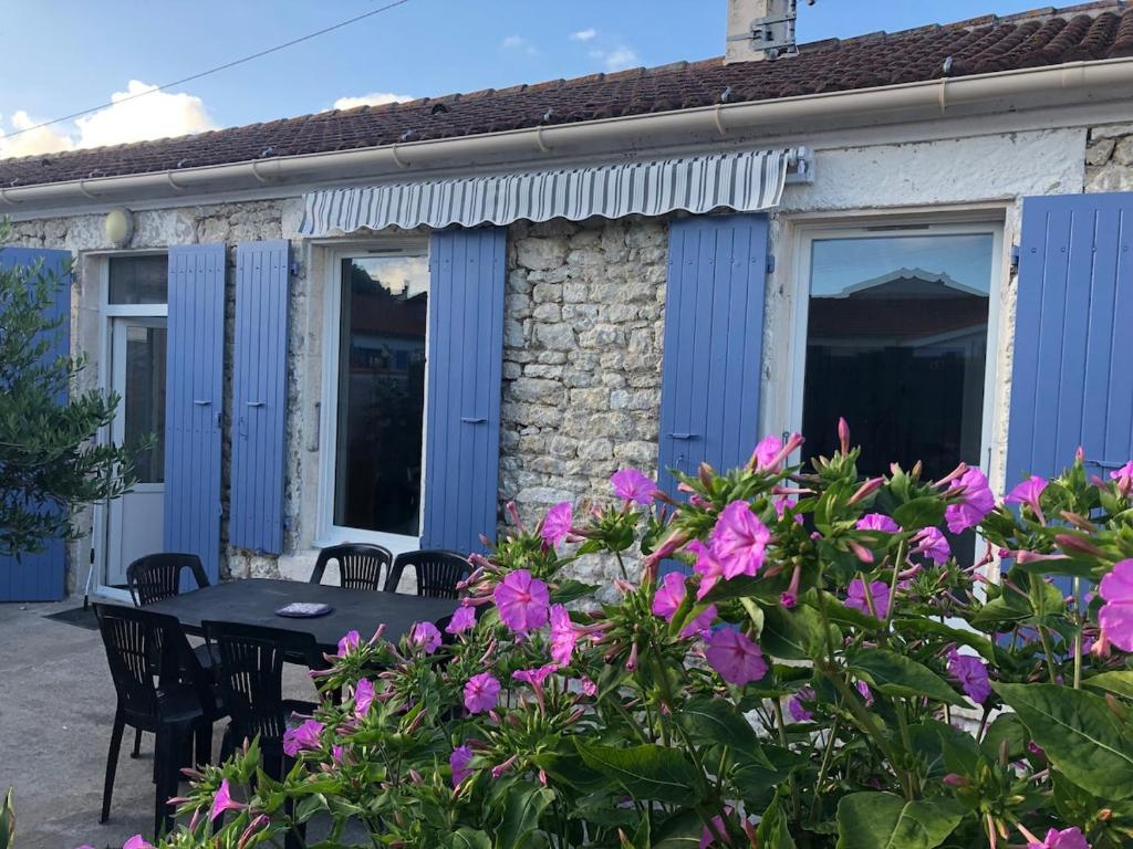 サン・ピエール・ドレロンにあるPort La Cotinière 100m plage et commercesの建物の前にテーブルと花が飾られたパティオ