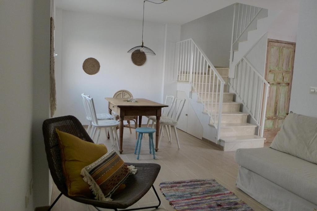 a living room with a table and a dining room at Casa Aurora Vejer in Vejer de la Frontera