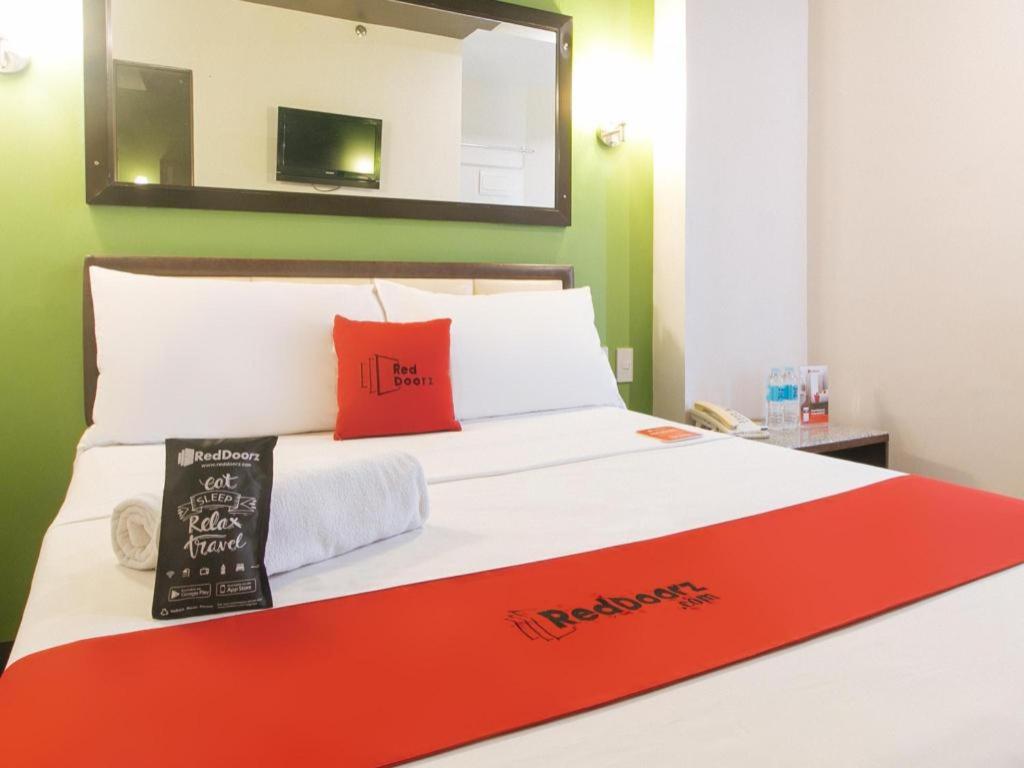 a bed with a red and white blanket on it at RedDoorz @ Express Inn Lapu Lapu in Gun-ob