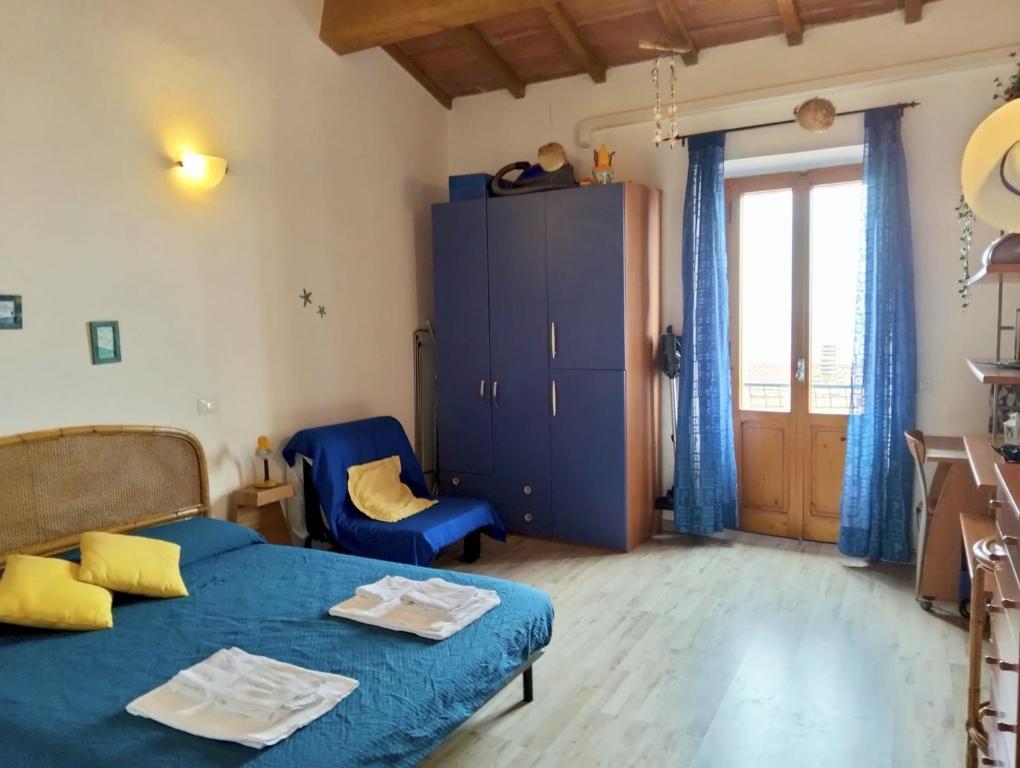 a bedroom with a blue bed and a blue chair at Bilocale in centro con vista mare in Porto Santo Stefano