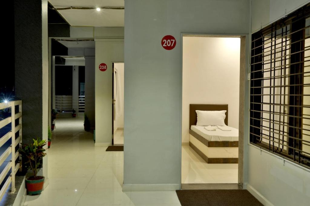 Hotel Sai Navsari客房内的一张或多张床位
