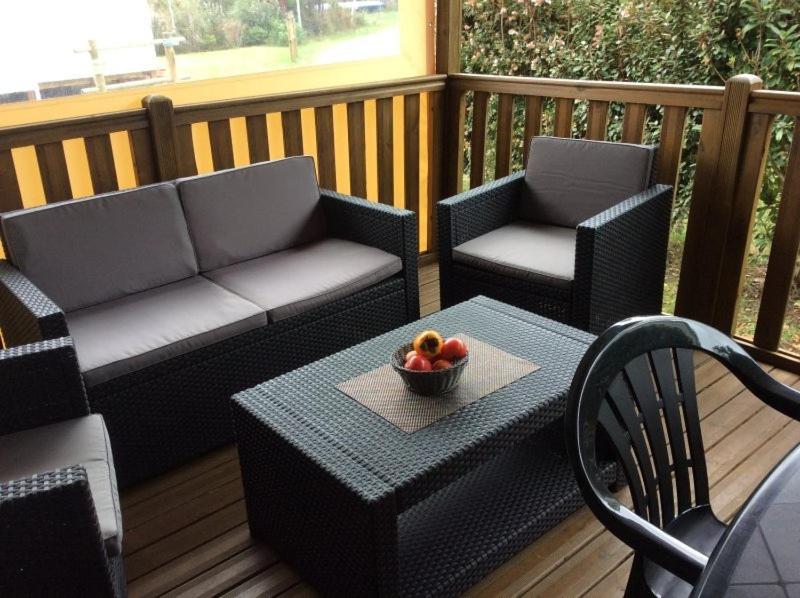 - une terrasse couverte avec 2 chaises et une table avec un bol de fruits dans l'établissement La détente, à Gastes