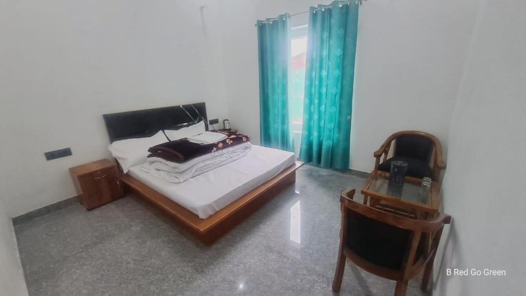 a bedroom with a bed and a table and a chair at Hotel Uday Villa in Kharsālī