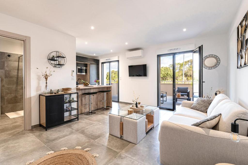 un salon avec un canapé et une cuisine dans l'établissement Les Vagues d'Agosta, à Albitreccia