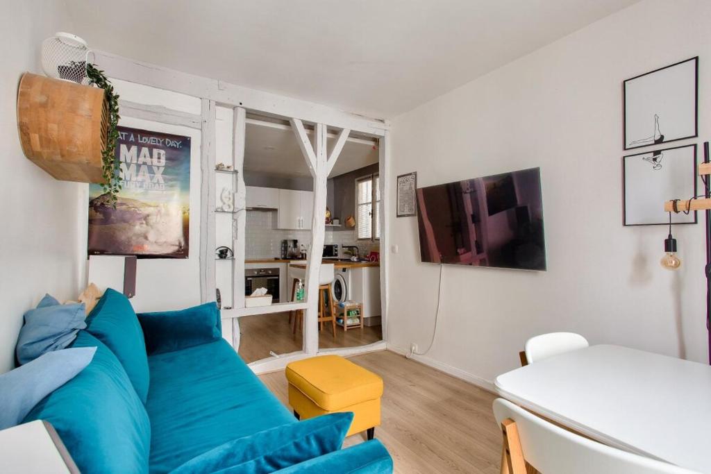 un salon avec un canapé bleu et une table dans l'établissement Charmant appart cosy et central, à Paris