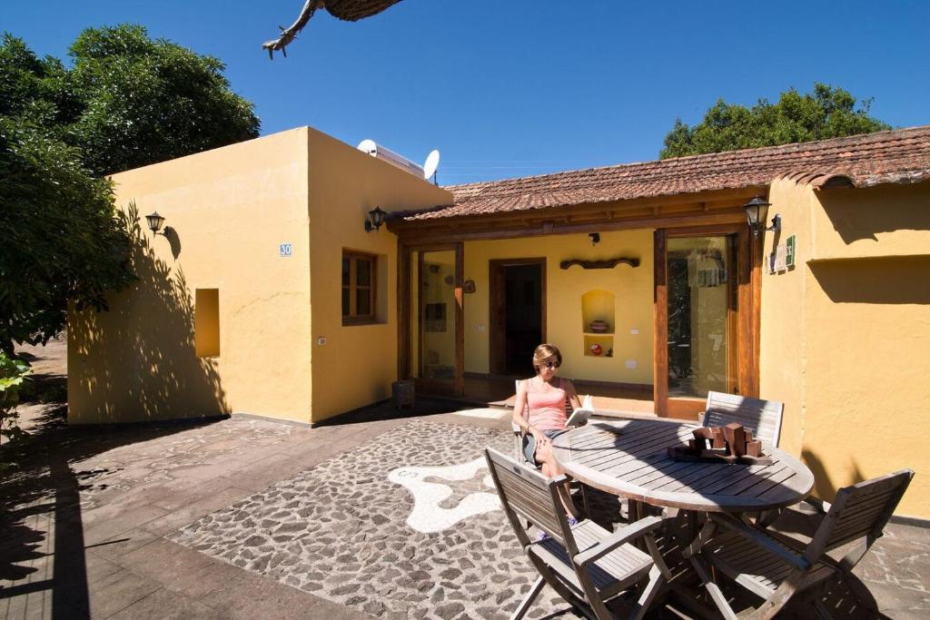 a woman standing next to a table in front of a house at Fontanales Pelibuey by Villas Rivero in Moya